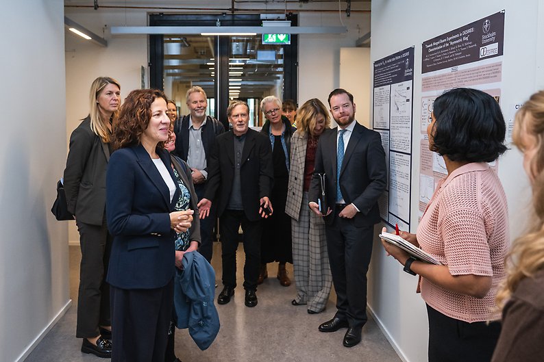Roxana Mînzatu with a group of people in a corridor at the Department of Physics